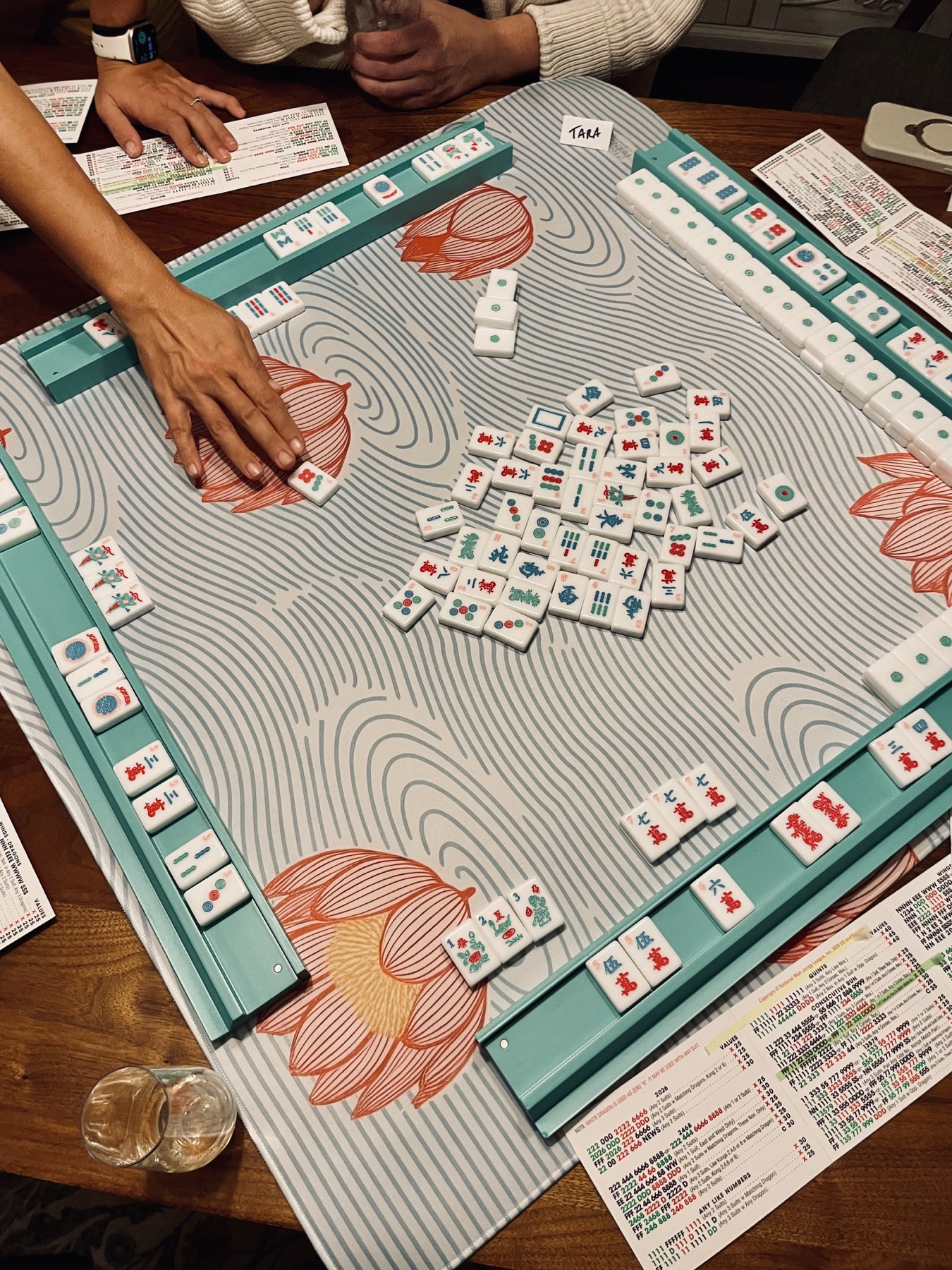 Players practicing American Mahjong together around a lotus playing mat