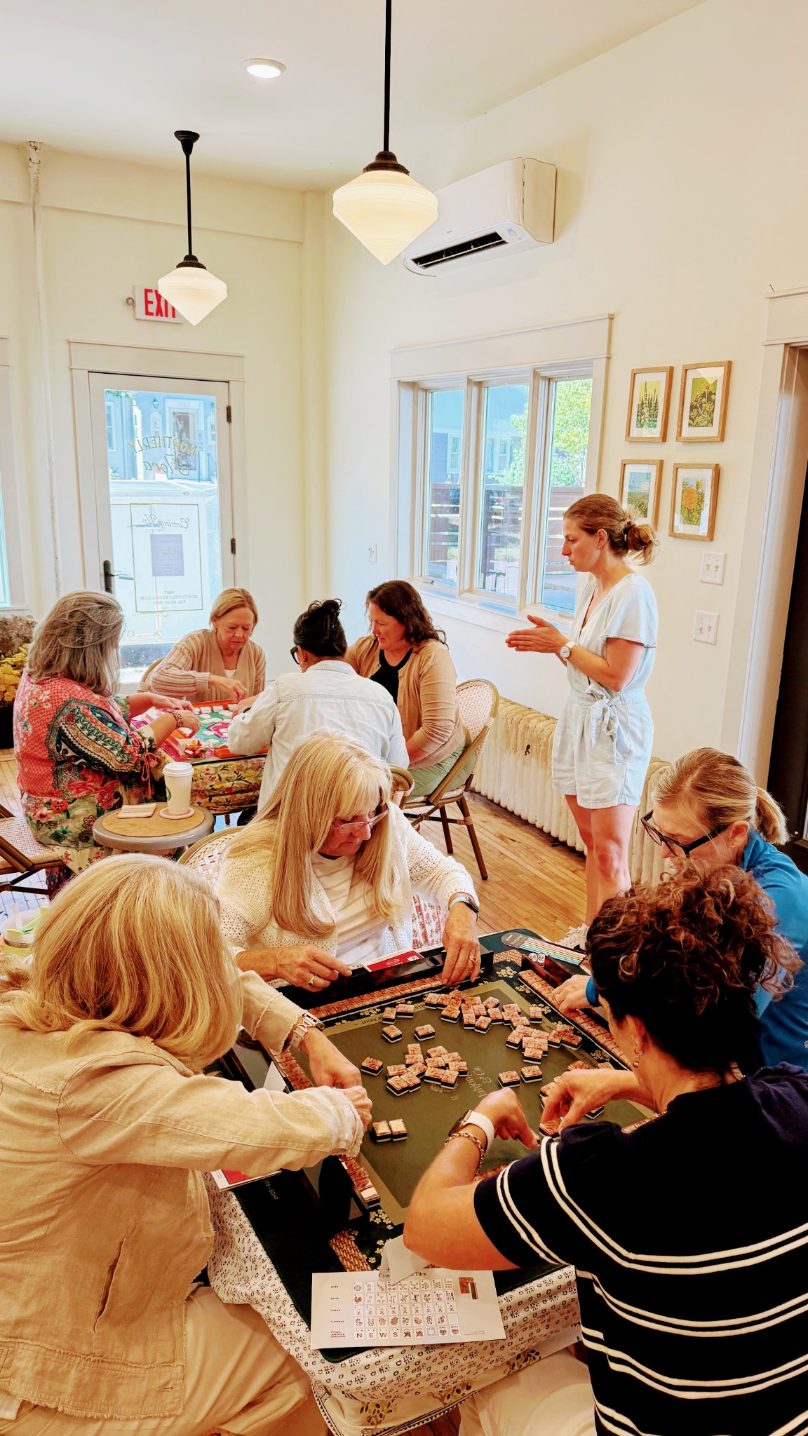 An instructor teaching while two tables play at Northerly Flora