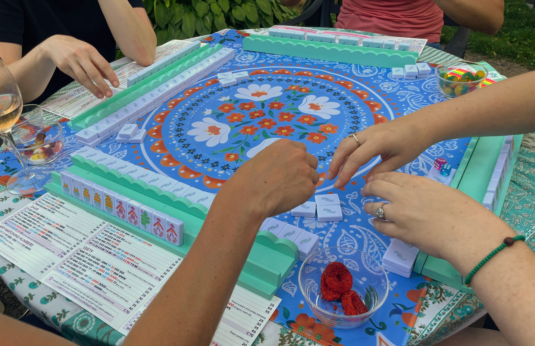 Friends learning mahjong around a colorful table